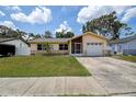 Welcoming single-story home with a well-maintained lawn, stone accents and attached garage at 6460 101St N Ave, Pinellas Park, FL 33782