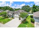 Aerial view of a charming single-story home with a well-manicured lawn and a three-car garage at 679 Challice Dr, Spring Hill, FL 34609