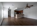 Open-concept living space with hardwood floors connecting the kitchen and dining area at 6940 47Th N Way, Pinellas Park, FL 33781