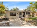 Single story home featuring updated paint, well-manicured landscaping, and a concrete driveway at 8009 Somerset Ln, Tampa, FL 33615