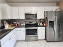 Bright kitchen features stainless steel appliances, white cabinets, and dark countertops at 8313 Arabian Dunes Pl, Riverview, FL 33578