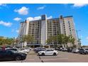Exterior shot of a modern condo building with well-maintained parking and surrounding landscaping at 9425 Blind Pass Rd # 1008, St Pete Beach, FL 33706