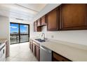 Functional kitchen space offering warm wood cabinets and views of the water from a picture window at 9425 Blind Pass Rd # 1008, St Pete Beach, FL 33706