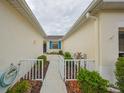 Inviting walkway with white railings leading to the home's entrance with bright blue window at 1012 Radison Lake Ct # 59, Sun City Center, FL 33573