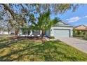 Lovely home featuring a manicured lawn, lush tropical landscaping and an attached two-car garage at 11806 Holly Crest Ln, Riverview, FL 33569