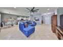 Open-concept living space with tile flooring, modern decor, and a comfortable blue sectional sofa at 11806 Holly Crest Ln, Riverview, FL 33569