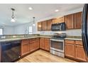 Well-lit kitchen featuring stainless steel appliances, wood cabinets, and granite countertops at 11837 Thicket Wood Dr, Riverview, FL 33579