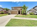 Charming two-story home with a two car garage, beautiful lawn, and a driveway at 12316 Streambed Dr, Riverview, FL 33579