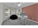 Well-lit office space with multiple windows, a modern desk, and comfortable seating at 13910 Chalk Hill Pl, Riverview, FL 33579