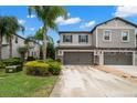 This is an exterior view of a modern home featuring a two-car garage and well-maintained landscaping at 1395 White Fox Run, Lutz, FL 33549