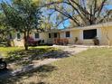 Single-story home with large window and mature landscaping at 15034 Lake Magdalene Blvd, Tampa, FL 33618