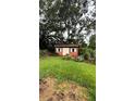 Exterior view of shed with double doors, surrounded by trees and landscaping at 19036 Blake Rd, Odessa, FL 33556