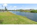 Scenic waterfront view of a lake bordered by lush green grass and beautiful homes at 213 Fernwood Cir # 213, Seminole, FL 33777