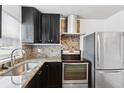 Modern kitchen with stainless steel appliances, granite countertops, and a stylish backsplash at 2834 Somerset Park Dr, Tampa, FL 33613