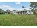 Expansive backyard featuring a green lawn, some trees, and a wooden fence providing privacy at 3118 Adrian Ave, Largo, FL 33774