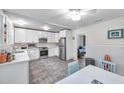 Bright kitchen features white cabinetry, stainless appliances, tile floors, and a ceiling fan at 320 Broadway, Dunedin, FL 34698