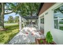 Home's exterior features white stucco, a pergola, decorative stones and a beautifully landscaped walkway at 3812 W Rogers Ave, Tampa, FL 33611