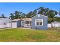 View of the blue home showcasing the attached garage, fenced yard, and proximity to neighboring houses at 4012 N Munro St, Tampa, FL 33603