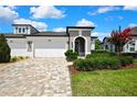 Charming home with a paver driveway, manicured landscaping, and a three-car garage at 4155 Barletta Ct, Wesley Chapel, FL 33543