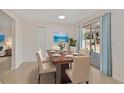 Elegant dining room with a wood table set for six, complemented by natural light and sliding glass doors at 4714 W Vasconia St, Tampa, FL 33629