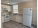Bright kitchen featuring white cabinets, granite countertops, stainless steel appliances, and a window for natural light at 4793 Pleasant Ave, Palm Harbor, FL 34683