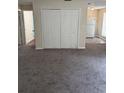 Spacious living room featuring new carpet and ample natural light from a window adjacent to a large closet at 4793 Pleasant Ave, Palm Harbor, FL 34683
