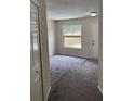 Inviting living room with plush carpet, large window offering ample natural light, and neutral paint tones at 4793 Pleasant Ave, Palm Harbor, FL 34683