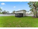 Expansive backyard with a dark screened-in porch and white privacy fence at 4918 Stolls Ave, Tampa, FL 33615