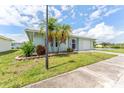 Pleasant home featuring a well-maintained lawn, mature palm trees, and an attached garage at 5377 Springwood Blvd, Pinellas Park, FL 33782