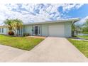Inviting single-story home with lush lawn, mature palm trees, and a convenient attached garage at 5377 Springwood Blvd, Pinellas Park, FL 33782