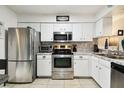 Modern kitchen featuring stainless steel appliances and sleek white cabinets at 6630 Spring Flower Dr # 14, New Port Richey, FL 34653