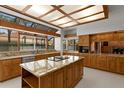 Spacious kitchen with granite countertops, large windows, and an island with an electric cooktop at 7114 Pelican Island Dr, Tampa, FL 33634