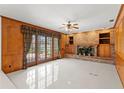 Inviting living room with brick fireplace, wood paneled walls, and french doors leading to the patio at 7114 Pelican Island Dr, Tampa, FL 33634