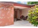 Inviting front porch featuring seating, a ceiling fan, and brick accents at 7276 21St Street N, St Petersburg, FL 33702