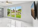 Sunlit living room featuring a large window with neighborhood views and sleek, glossy marble floors at 7930 Jeffery Ave, North Port, FL 34287