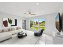 Bright living room with large windows, modern furniture, and sleek tile flooring creating an open, airy space at 7930 Jeffery Ave, North Port, FL 34287