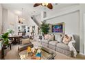 Spacious living room with plush sofa, large windows, and staircase at 9616 Carlsdale Dr, Riverview, FL 33578