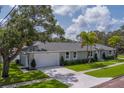 Well-kept home with lush lawn, mature trees and a two-car garage, situated on a desirable corner lot at 102 7Th Se Ave, Largo, FL 33771