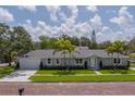 Attractive single-story home with well-maintained lawn and complemented by mature palm trees and lovely brick street at 102 7Th Se Ave, Largo, FL 33771