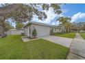 Side view of a home featuring an attached two-car garage, nicely landscaped lawn, and neutral exterior paint at 102 7Th Se Ave, Largo, FL 33771