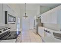 Bright kitchen featuring stainless steel appliances, white cabinets, quartz countertops, and tile floors at 10414 Hallmark Blvd, Riverview, FL 33578