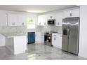 Modern kitchen with white cabinets, stainless steel appliances, and elegant marble countertops at 1109 N Obrien St, Tampa, FL 33607