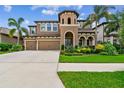 Stunning two-story home featuring a three-car garage and lush landscaping in a tropical setting at 11407 Drifting Leaf Dr, Riverview, FL 33579