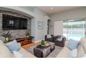 Inviting living room featuring a stone accent wall, modern furniture, and sliding glass doors to the pool area at 11623 Greensleeve Ave, Tampa, FL 33626