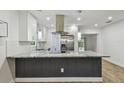 Modern kitchen featuring granite countertops, stainless steel appliances, and a stylish island with seating at 1311 W Perdiz St, Tampa, FL 33612
