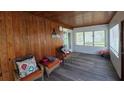 Cozy sunroom featuring wood-paneled walls, seating, and natural light at 13330 Fort King Rd, Dade City, FL 33525