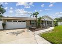 The exterior of this home features a well manicured lawn with lush green grass and a driveway leading to the garage at 1410 Moss Laden Ct, Brandon, FL 33511