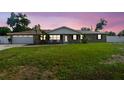 Charming home front view at sunset, features a cozy porch, green lawn, & beautiful landscaping at 1410 Moss Laden Ct, Brandon, FL 33511