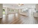 Spacious open-concept living room and kitchen area, featuring modern lighting and beautiful hardwood floors at 1410 Moss Laden Ct, Brandon, FL 33511