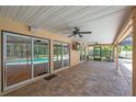 Covered brick paver patio featuring ceiling fans and sliding glass doors that offer seamless indoor/outdoor living at 1695 Cinnamon Ln, Dunedin, FL 34698